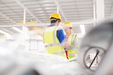 Smiling female worker talking with coworkers in factory