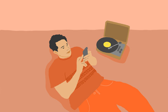 Young man laying on floor with phone and record player