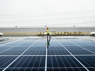  male engineer checks a photovoltaic (solar) plant and uses a recording tablet. mechanic in protective helmet. Man in uniform holding tablet.