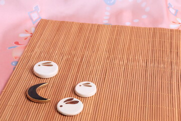 Japanese backgound. chopstick stands with the image of a moon rabbit on the background of a bamboo mat and pink fabric in a traditional style. The concept of the mid-autumn