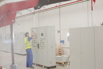 Engineer working at control panel in factory