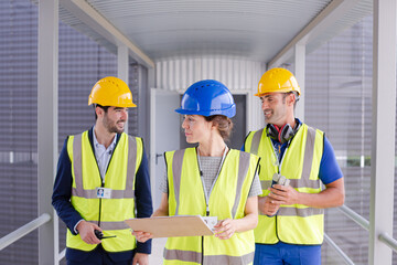 Supervisors and worker with clipboard in factory