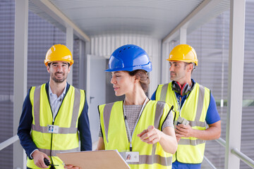 Supervisors and worker with clipboard in factory