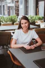 Young smiling woman in a street cafe