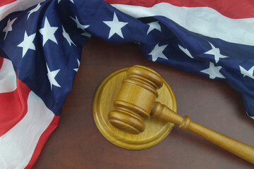Wooden judge gavel and United States flag. Court of USA concept.	