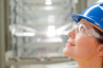 Profile pensive female worker looking up in factory