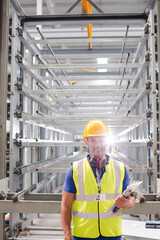 Portrait confident worker with clipboard in steel factory