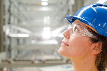 Profile pensive female worker looking up in factory