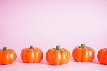 Halloween pumpkins on pink background, space for text, close-up. Halloween concept.
