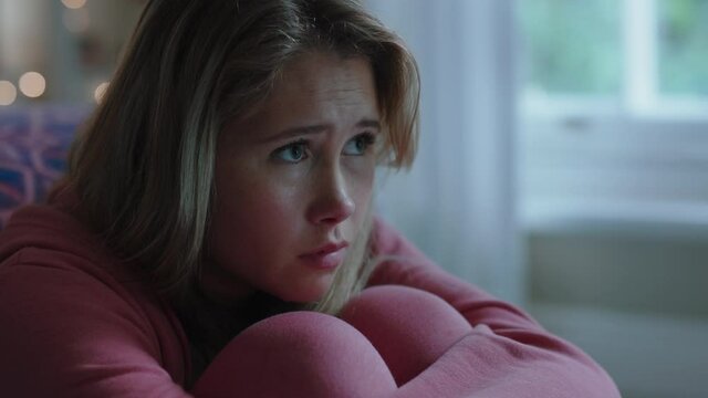 sad teenage girl crying at home feeling alone depressed teen thinking of emotional break up sitting in bedroom