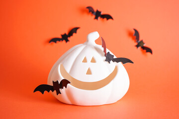 White halloween pumpkin and bats on an orange background. Halloween concept