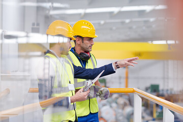 Supervisor and worker talking in steel factory