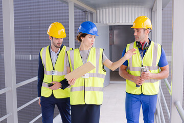Supervisors and worker with clipboard talking in factory