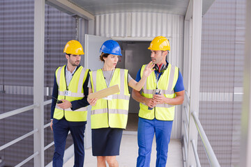 Supervisors and worker with clipboard talking in factory