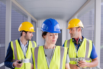 Supervisors and worker with clipboard in factory