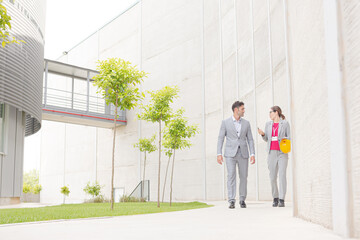 Supervisors walking on sidewalk below building