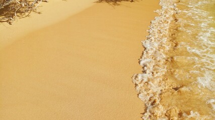 Sea waves on golden sand beach.