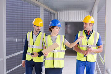 Supervisors and worker with clipboard talking in factory
