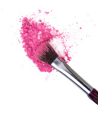 Crushed pink rouge eyeshadow cosmetic product and makeup brush isolated on the white background