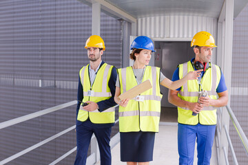 Supervisors and worker with clipboard talking in factory