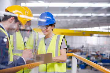 Supervisors and worker with clipboard talking in factory