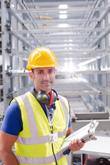 Portrait confident worker with clipboard in steel factory