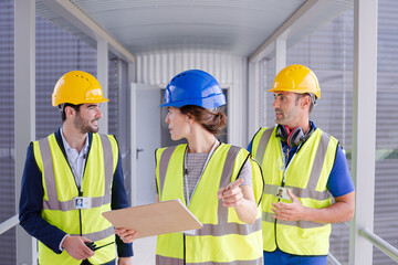 Supervisors and worker with clipboard in factory