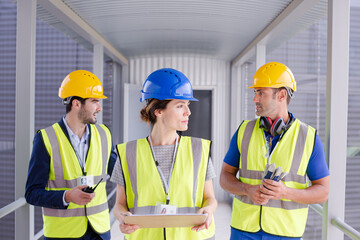 Supervisors and worker with clipboard in factory