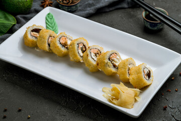 Hot roll with salmon tempura on black stone table
