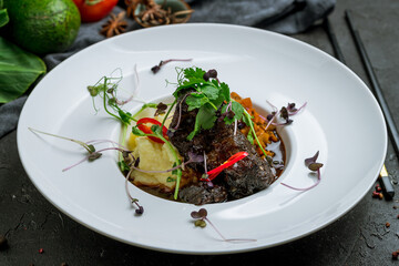 Beef cheeks with mashed potatoes on dark stone table