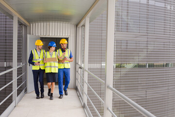 Supervisor and workers with clipboard talking in factory