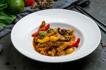 Spicy fragrant eggplant Chinese cuisine on white plate on black stone table