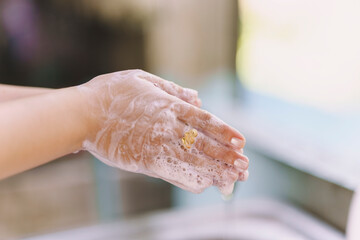 Woman washing hands with water flowing from the tap in the bathroom to keep clean and prevent the disease. Hygiene care concept.