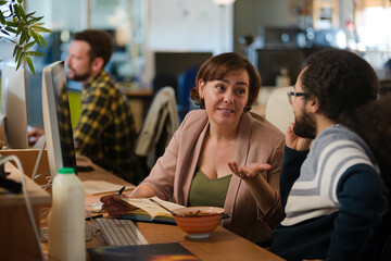 People working at desk, talking