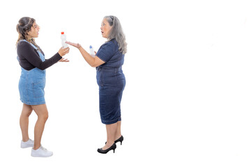 Fototapeta premium Mature mother explaining to her teenage daughter the importance of environmental awareness, two women with plastic bottles, light makeup, casual style, denim clothes. Space for text