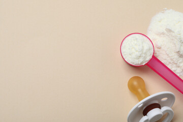 Flat lay of powdered infant formula with scoop and pacifier on beige background, space for text. Baby milk