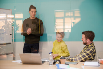 Man standing at whiteboard, leading conference room meeting
