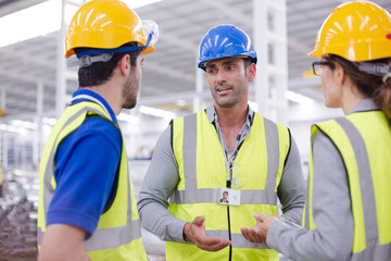 Supervisor and workers talking in steel factory