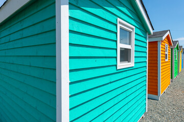 The exterior of a bright teal green narrow wooden horizontal clapboard wall of a house with one...