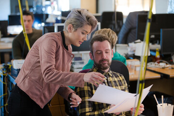 Two colleagues discussing paperwork in office