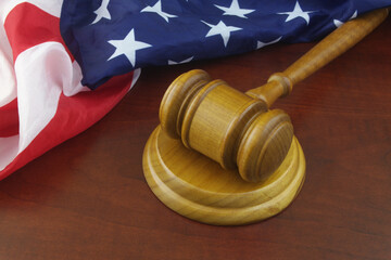 Wooden judge gavel and United States flag.  Court of USA concept.