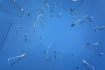 Broken glass with cracks on blue background