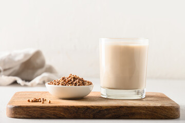 Buckwheat milk served in drinking glass with grain ingredient on a white background. Concept...