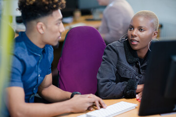 Two colleagues working together at computer