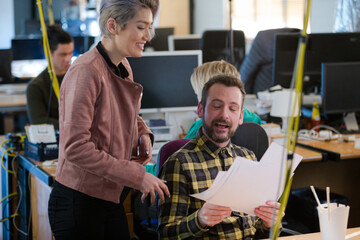 Two colleagues discussing paperwork in office