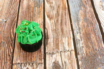 Homemade colorful cupcakes on wooden table.