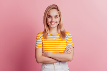 Portrait of self-assured girl folded hands on pink background
