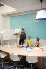 Man standing at whiteboard, leading conference room meeting
