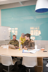 Obraz premium Three colleagues working at computer in conference room