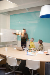 Man standing at whiteboard, leading conference room meeting